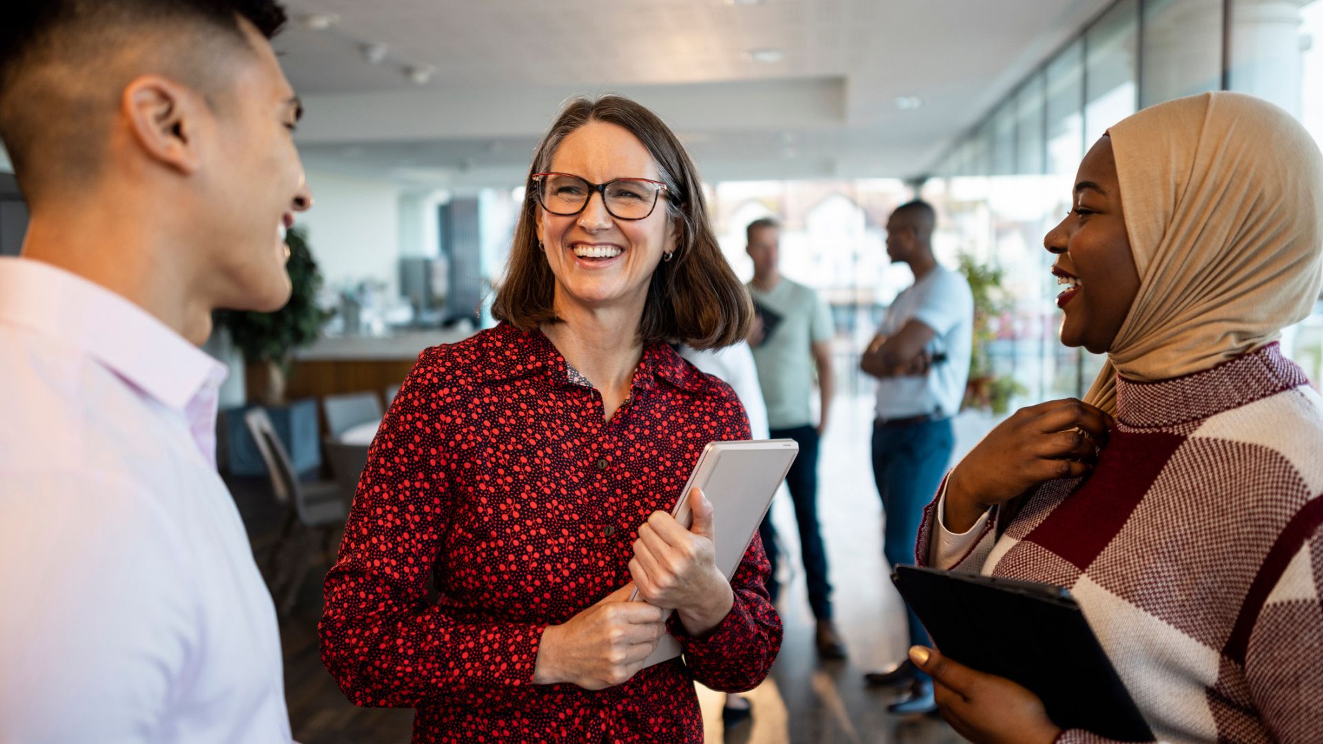 Three people in an office smiling together.