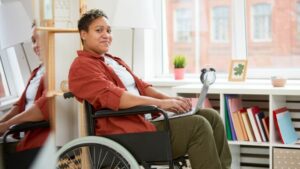 Side-on shot of person in a wheel chair looking at the camera.