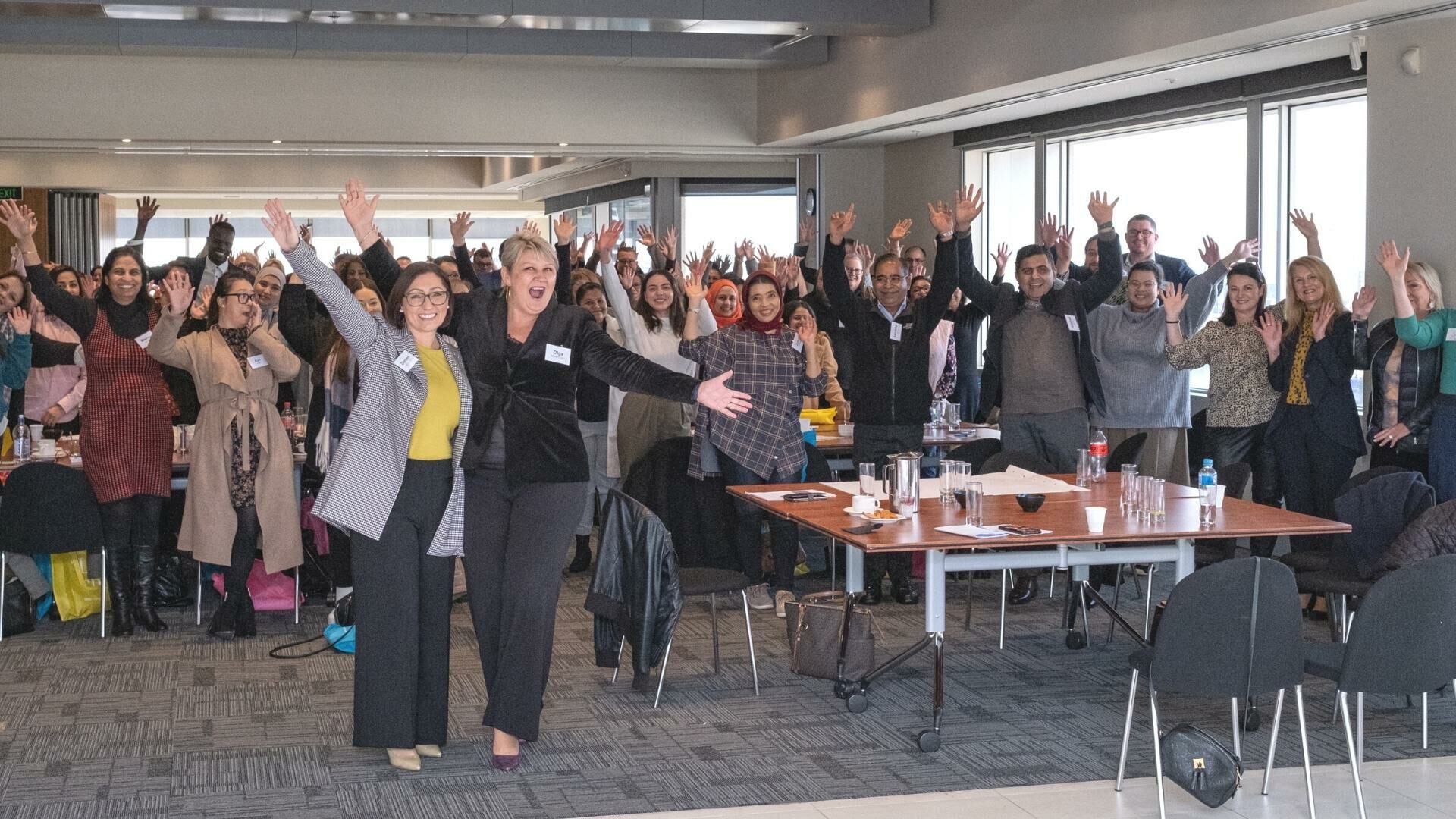 Group of employees with hands raised in celebration.