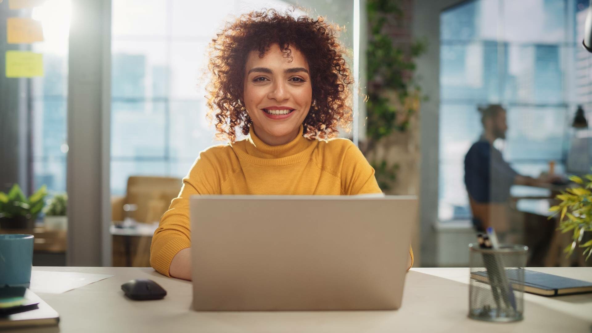 Smiling young woman at her work desk.