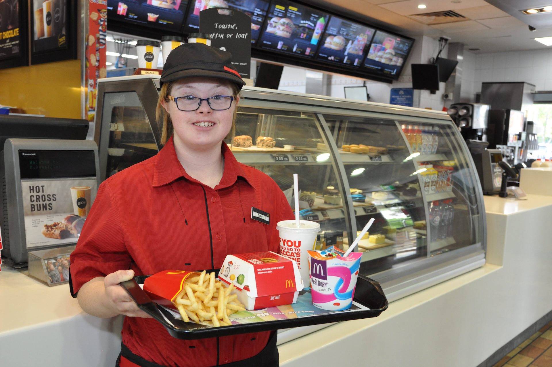Young female food crew holding a tray of fast food.