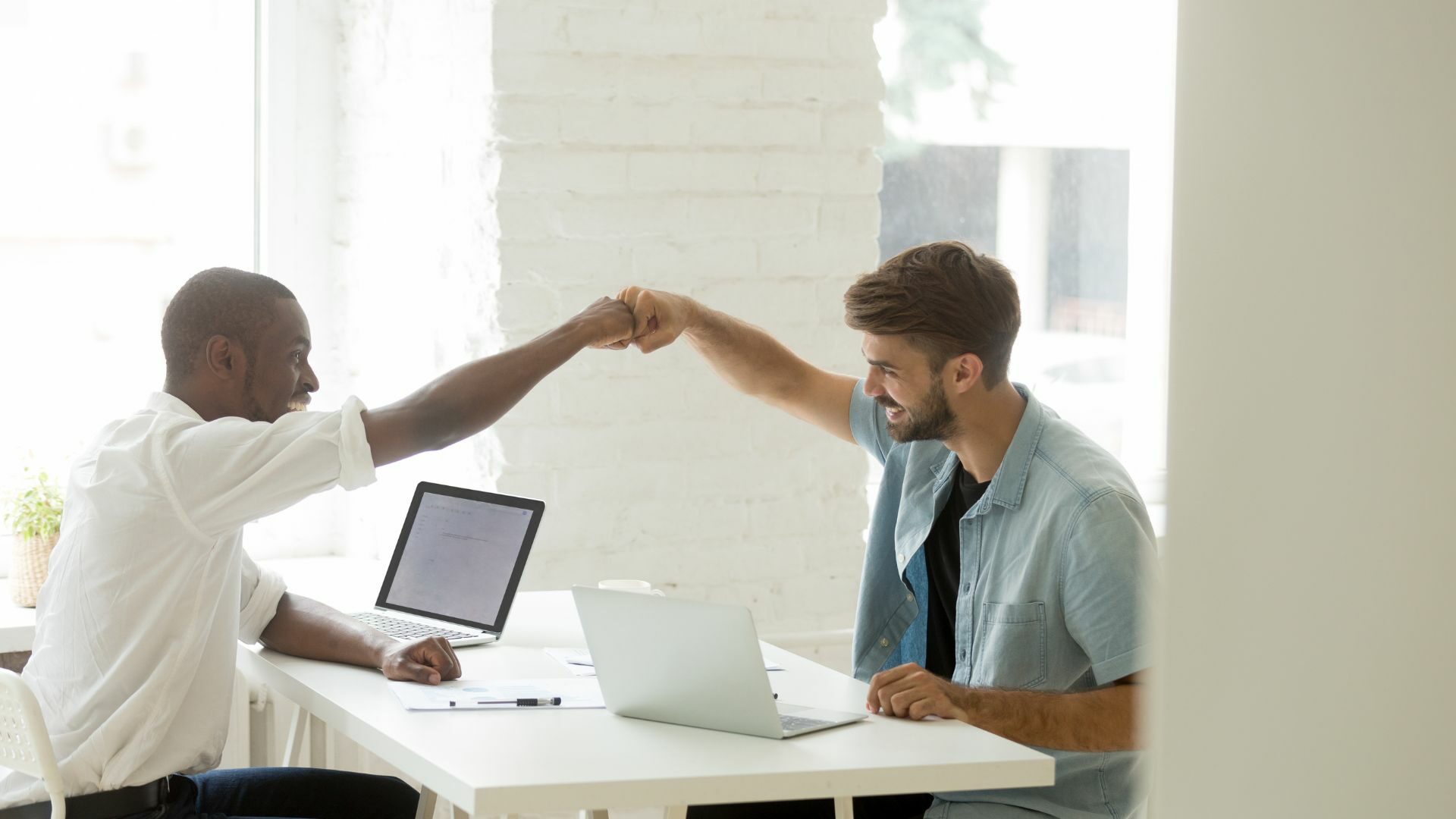 Two male coworkers doing a fist bump.