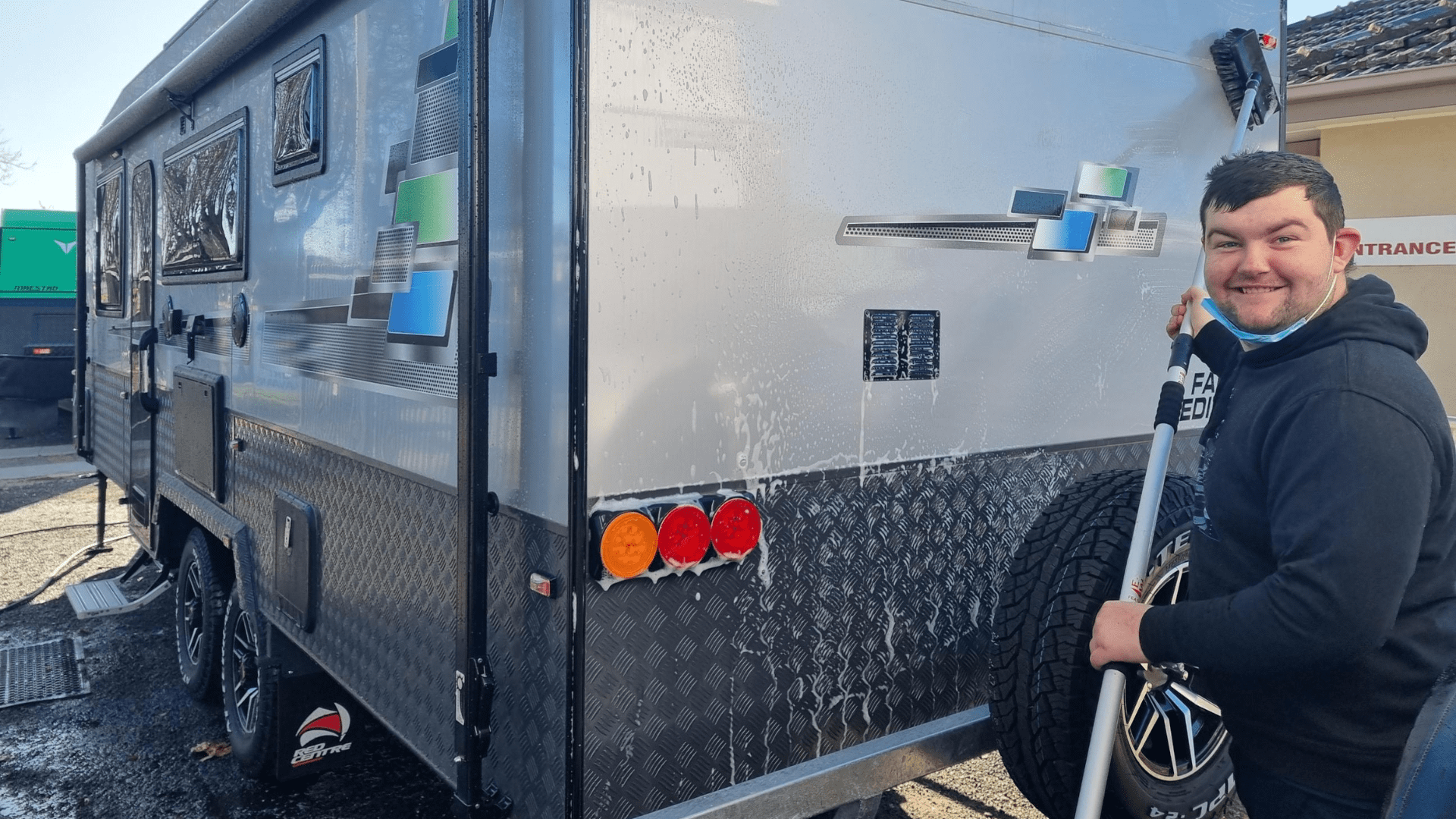 Young man washing a food truck.
