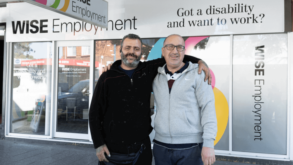 Abed standing next to Employment Consultant Baha in front of WISE Employment office