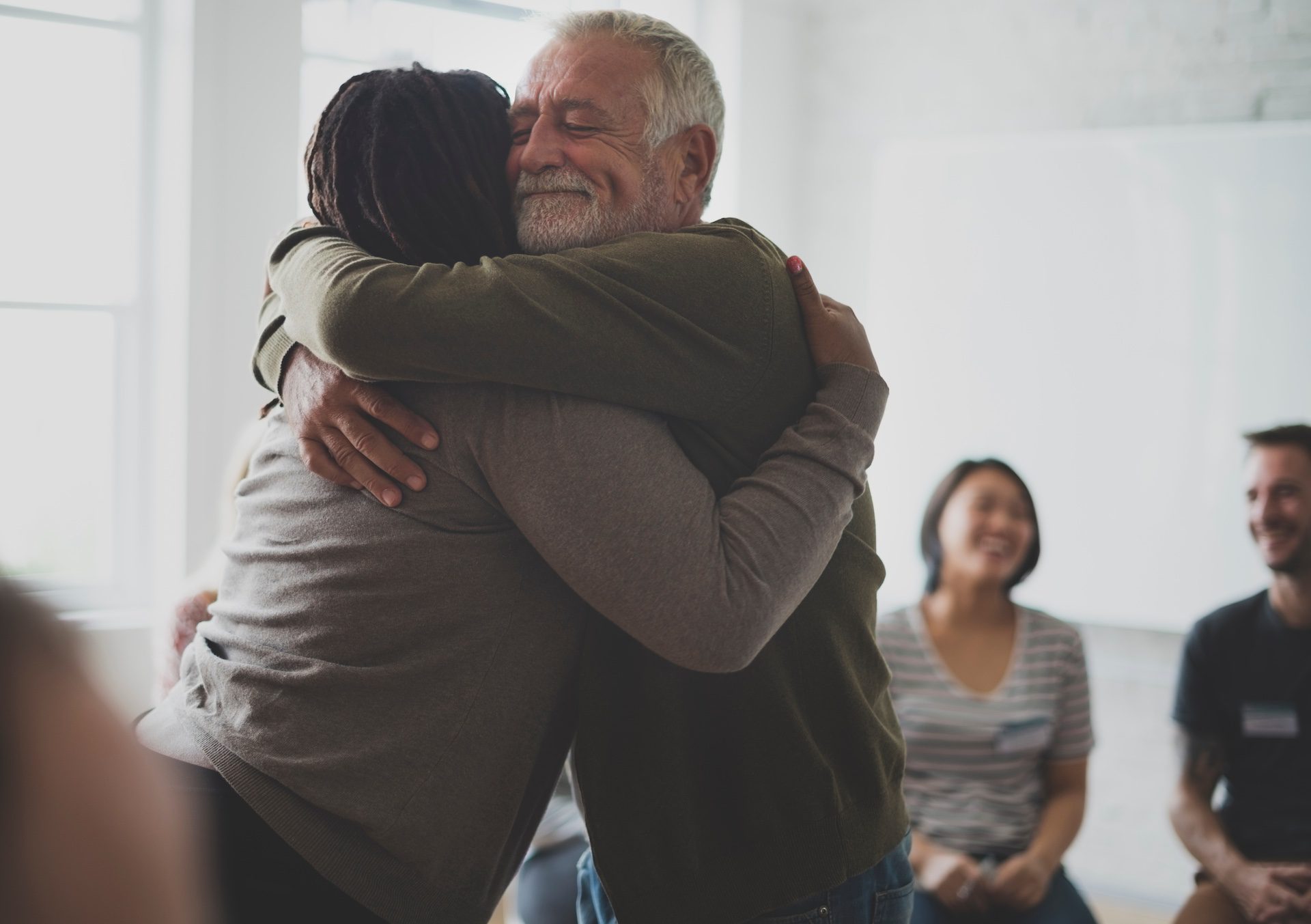 Old guy consoling a woman with a hug.