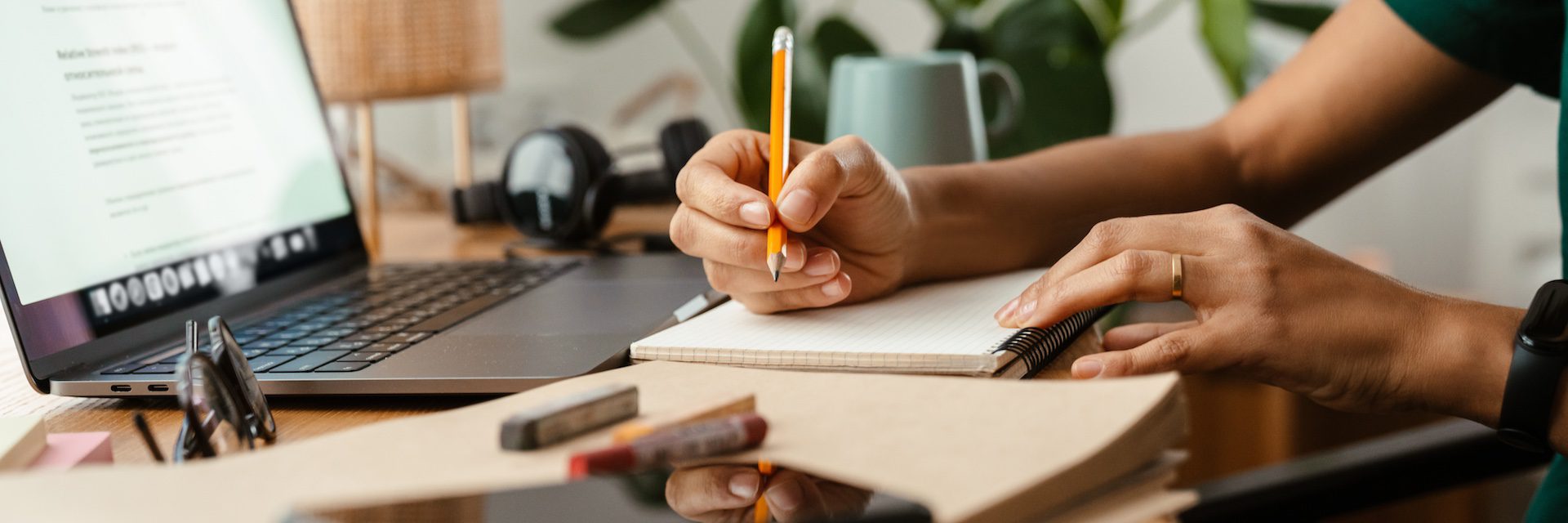 African American young woman using laptop and taking notes at home.