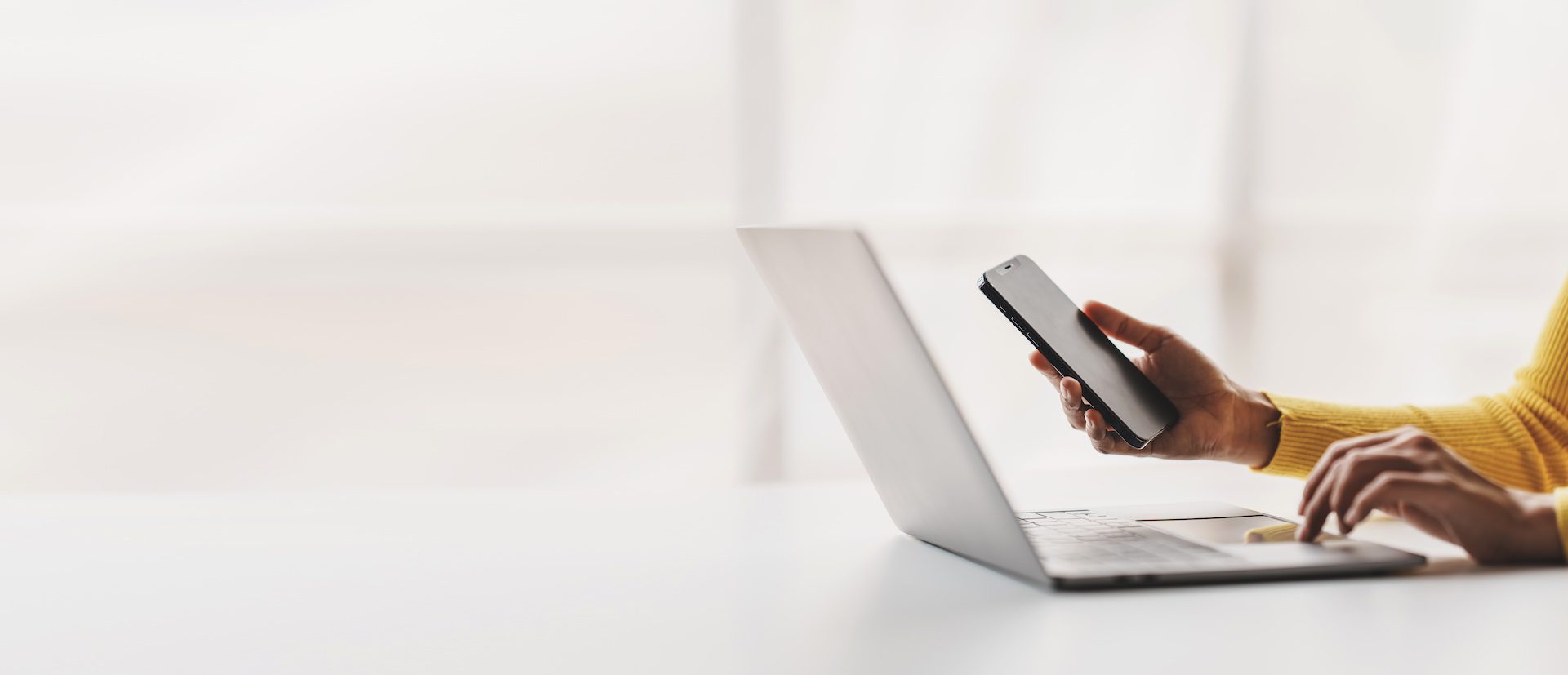 Businessman working with a smartphone, tablet, and laptop on a table in the office.