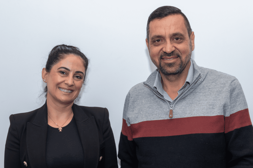 A man and a woman smiling at the camera.