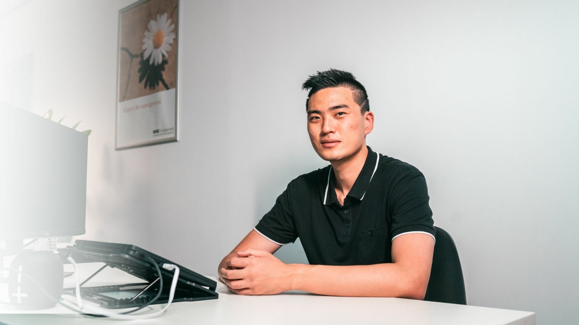 Young Asian man sitting at his work desk.