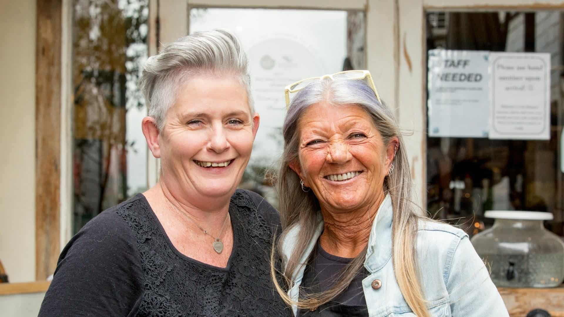 Two smiling middle-aged women.