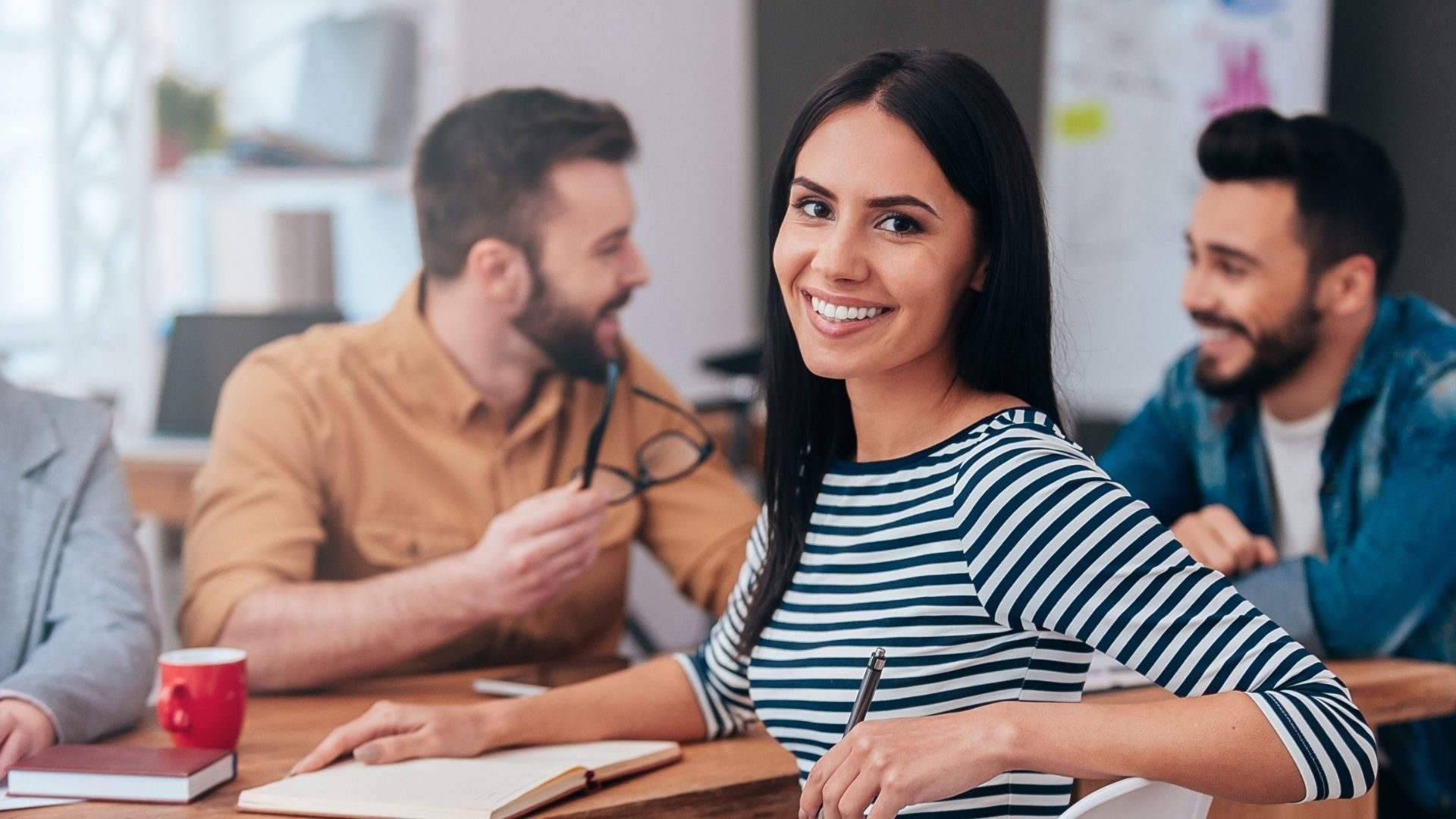 Young woman smiling during a group discussion.