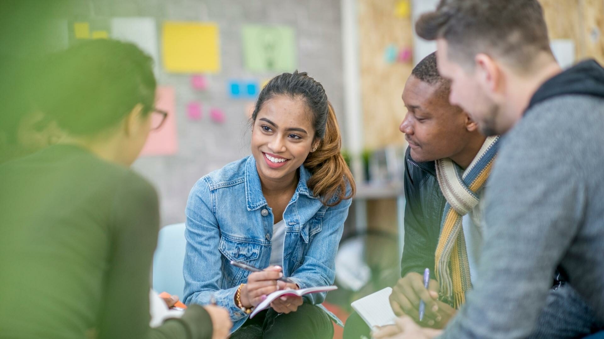 Young men and women engaged in a group discussion.