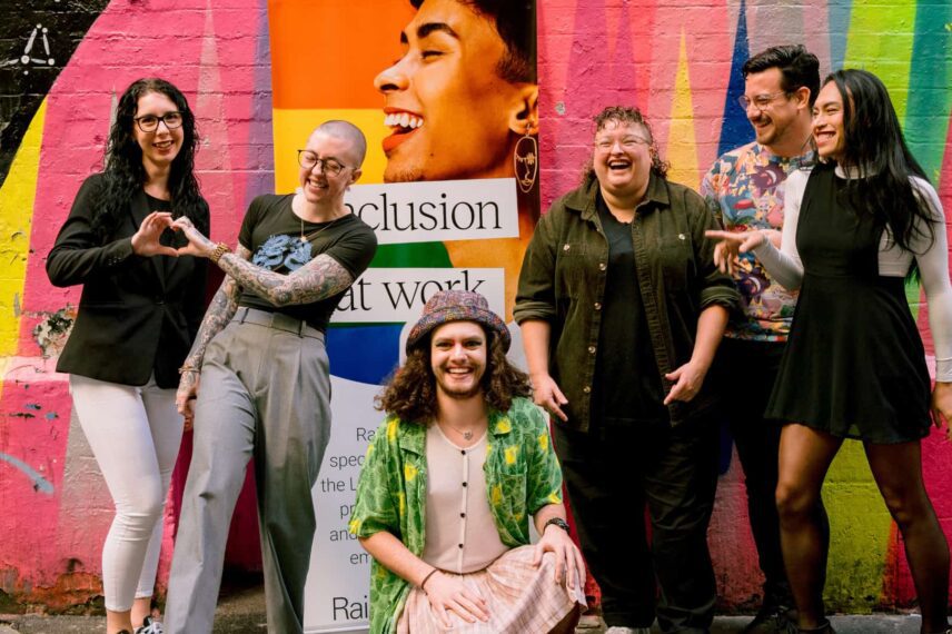 Rainbow WISE team with Noa in front of a colourful mural