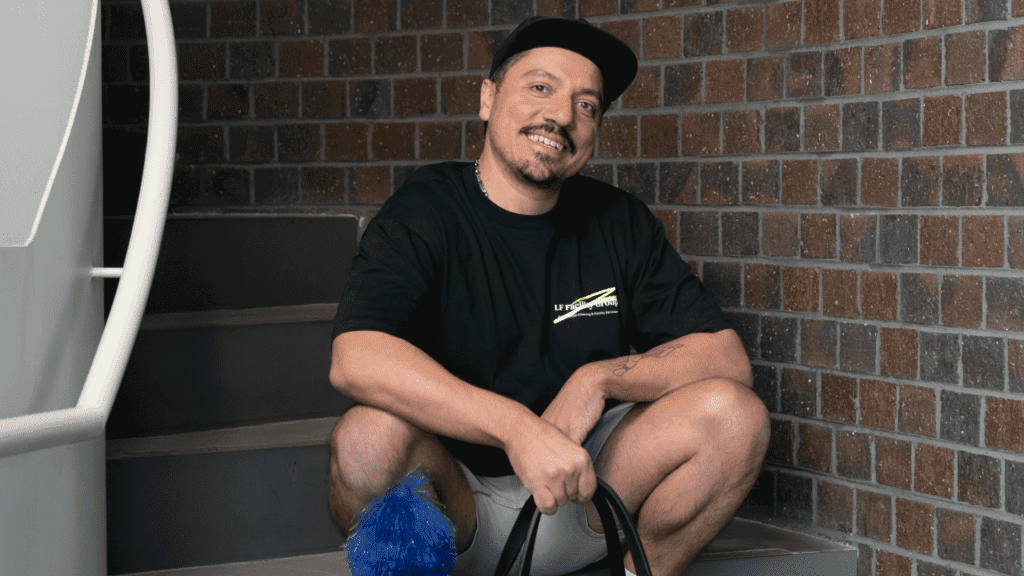 Man wearing a cap and sitting on stairs.