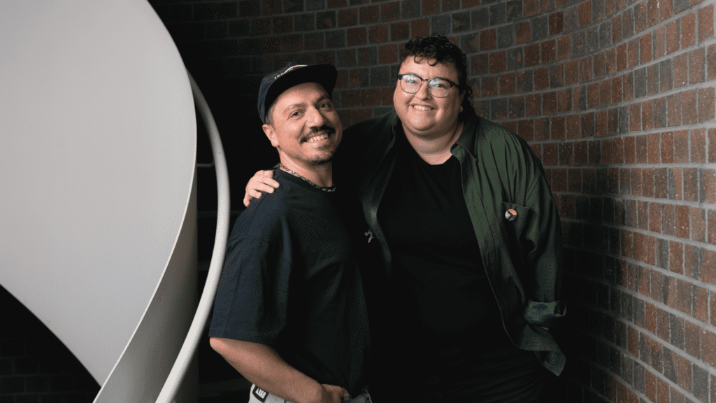 Man and woman in a stairway smiling at the camera.