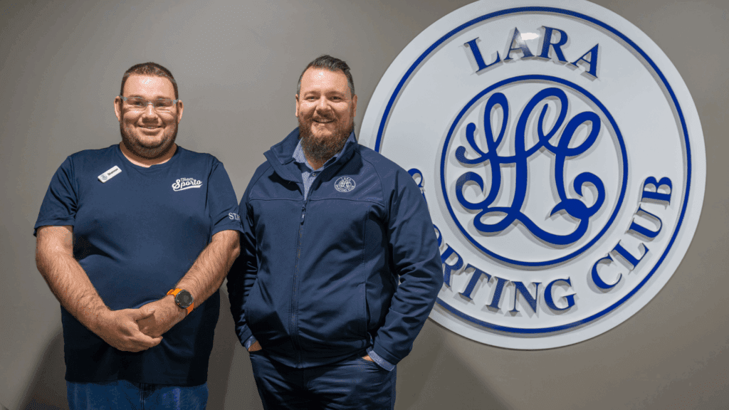 WISE customer Shannon and Brendon from Lara Sporting Club standing next to Lara Sporting Club signage indoors