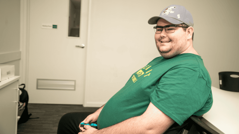 Noah smiling while playing a video game.